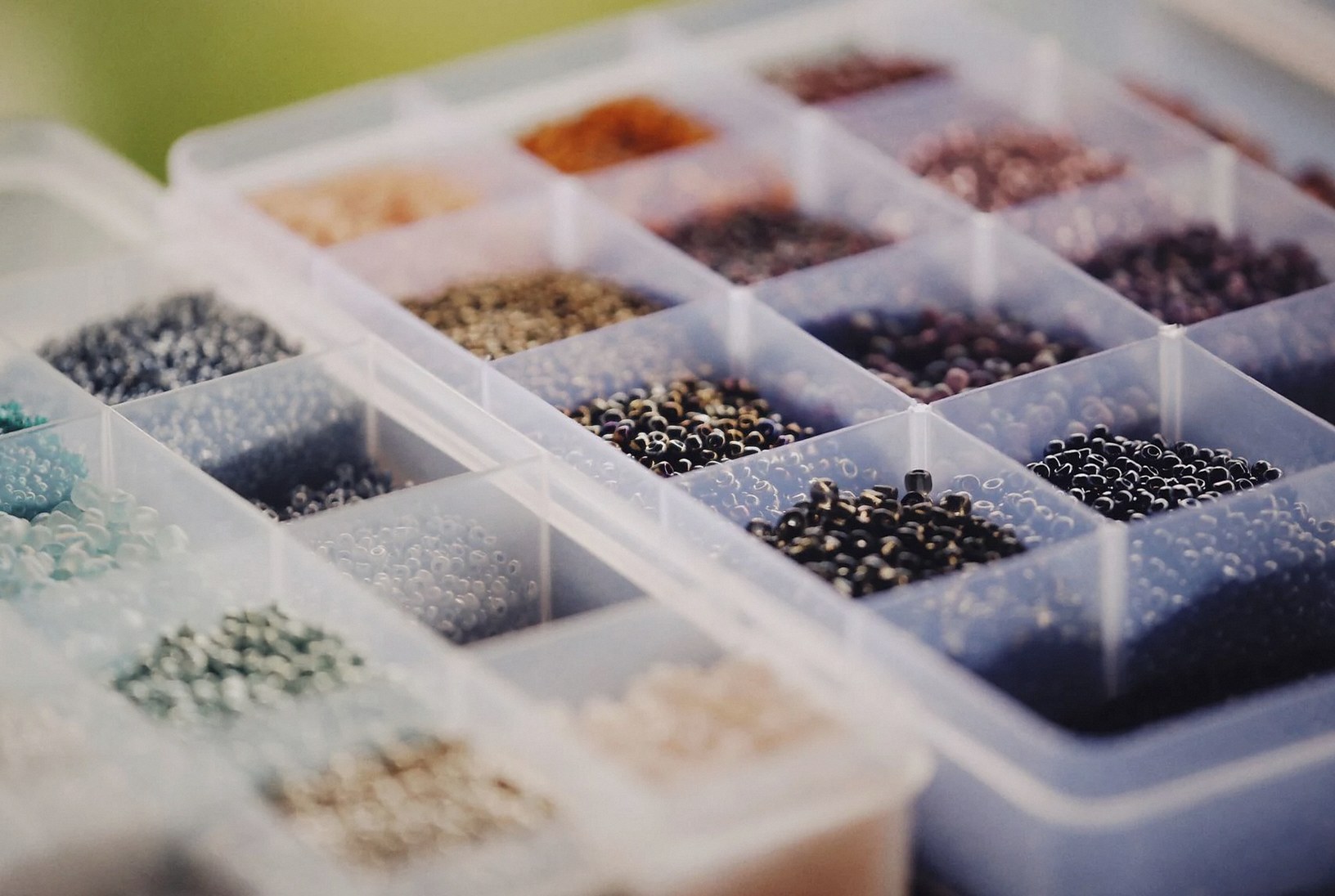鮮やかなビーズがプラスチック容器に色別に仕分けられており、クラフトやジュエリー作りに最適です。